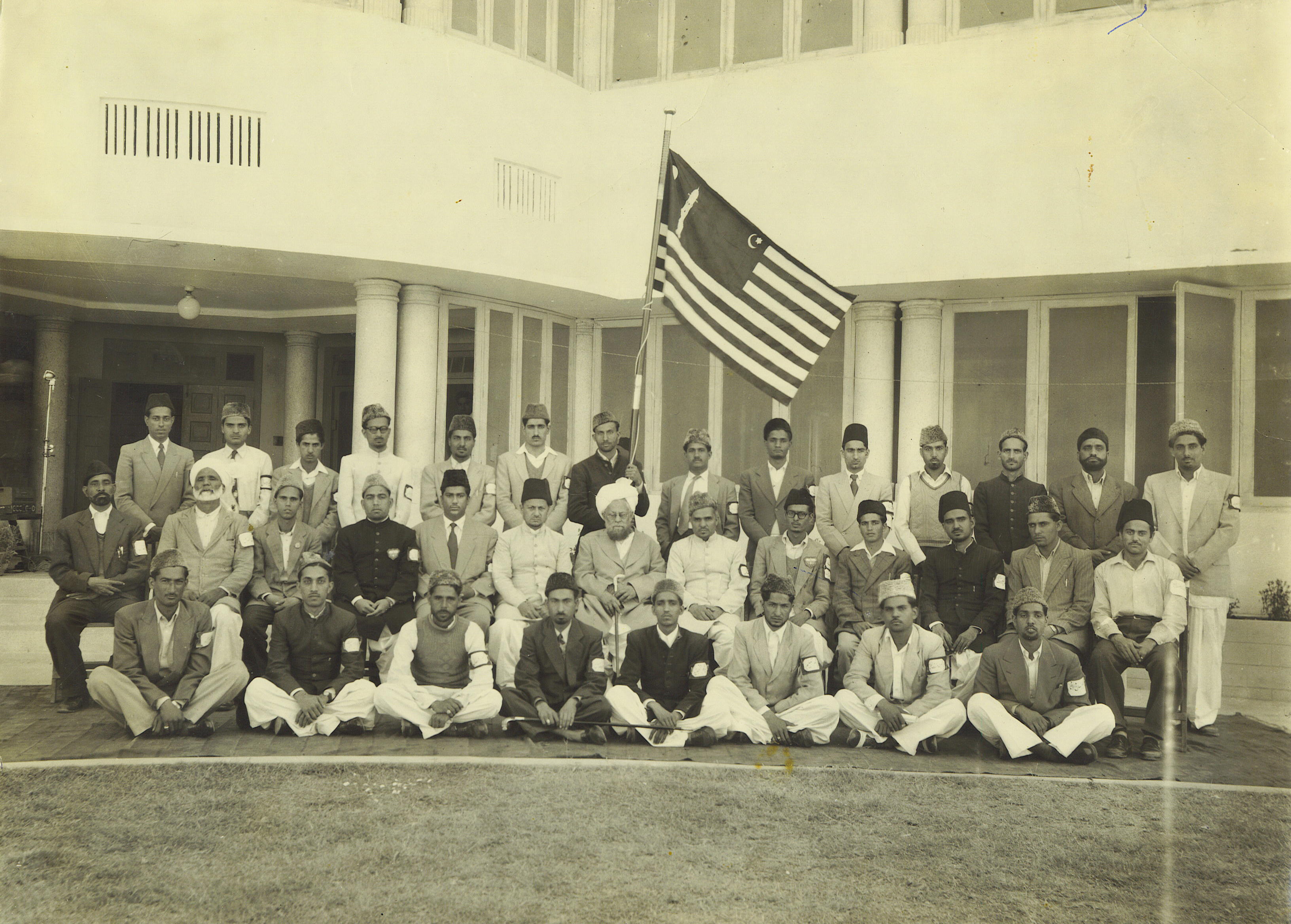 Khuddam holding a Khuddam Flag, a rare group photo with Khalifat–ul Masih II, Mirza Basheer-ud-Din Mahmood Ahmad